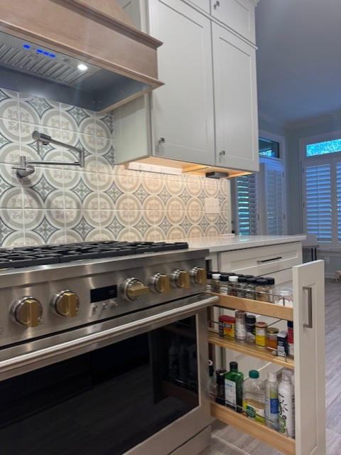 Eat-in kitchen - mid-sized transitional l-shaped porcelain tile and beige floor eat-in kitchen idea with an undermount sink, recessed-panel cabinets, white cabinets, quartz countertops, porcelain backsplash, stainless steel appliances, an island and white countertops
