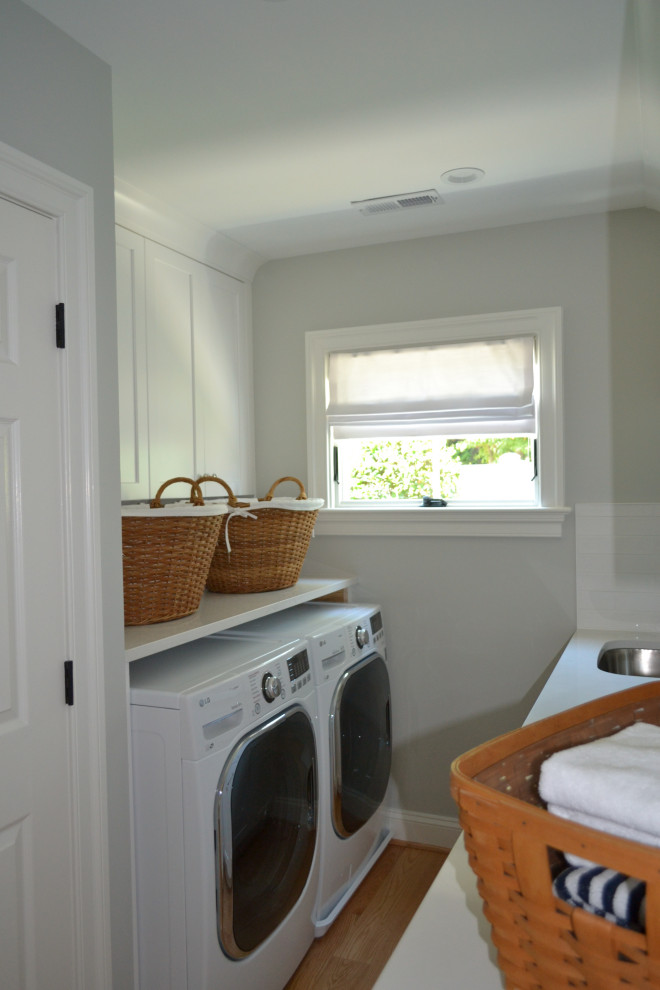 Design ideas for a medium sized beach style galley separated utility room in Baltimore with a submerged sink, shaker cabinets, white cabinets, engineered stone countertops, grey walls, medium hardwood flooring, a side by side washer and dryer, brown floors and white worktops.