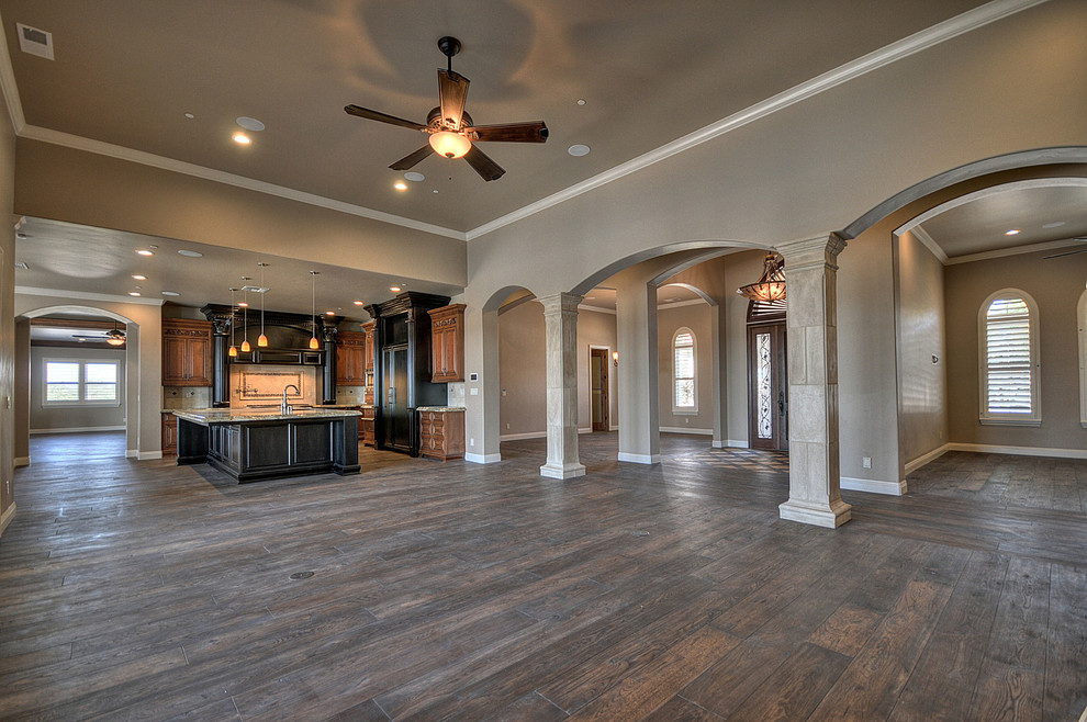 This is an example of a mediterranean open concept living room in Other with brown walls and dark hardwood floors.