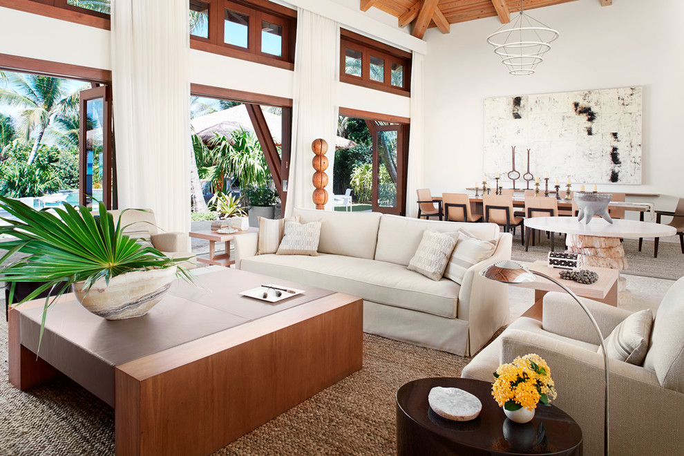 Large tropical open concept living room in Other with white walls.