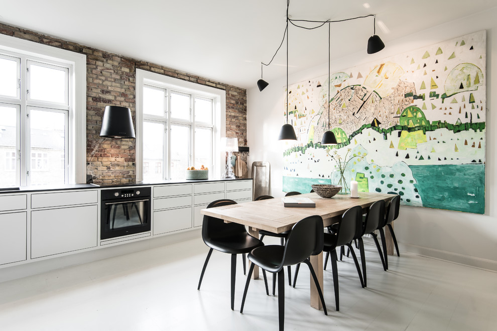 Photo of a scandinavian kitchen/dining combo in Odense with white walls.