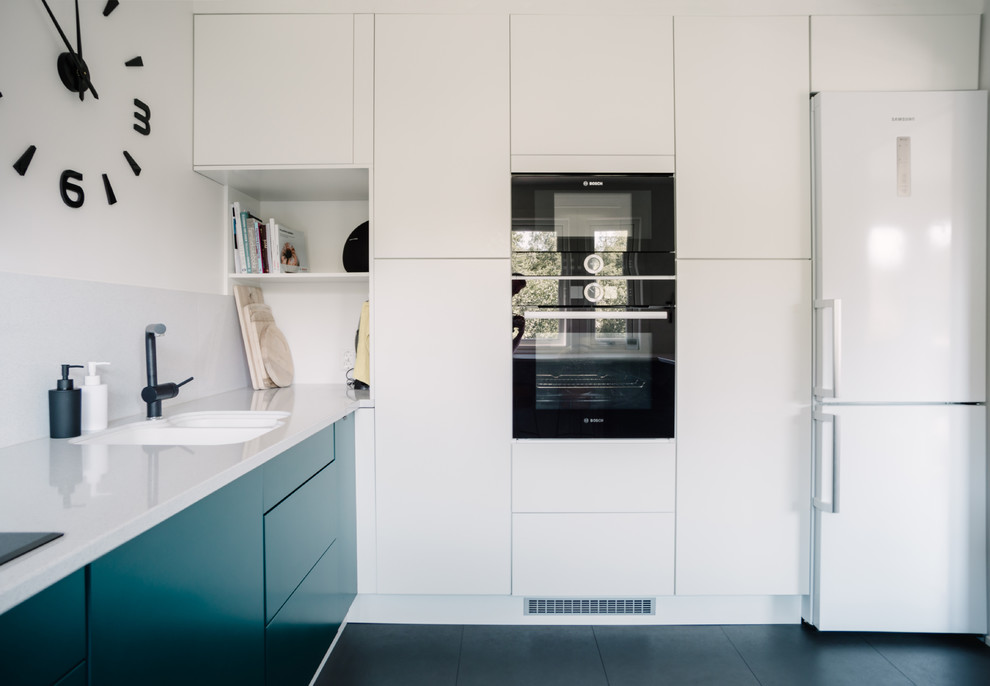 This is an example of a mid-sized modern u-shaped separate kitchen in Other with an undermount sink, flat-panel cabinets, green cabinets, quartz benchtops, white splashback, stone slab splashback, black appliances, vinyl floors, no island, black floor and white benchtop.