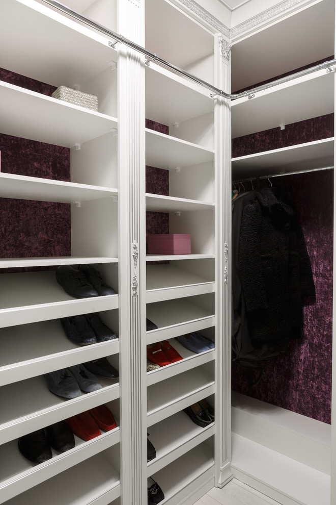 Medium sized gender neutral walk-in wardrobe in Moscow with raised-panel cabinets, white cabinets, medium hardwood flooring and brown floors.
