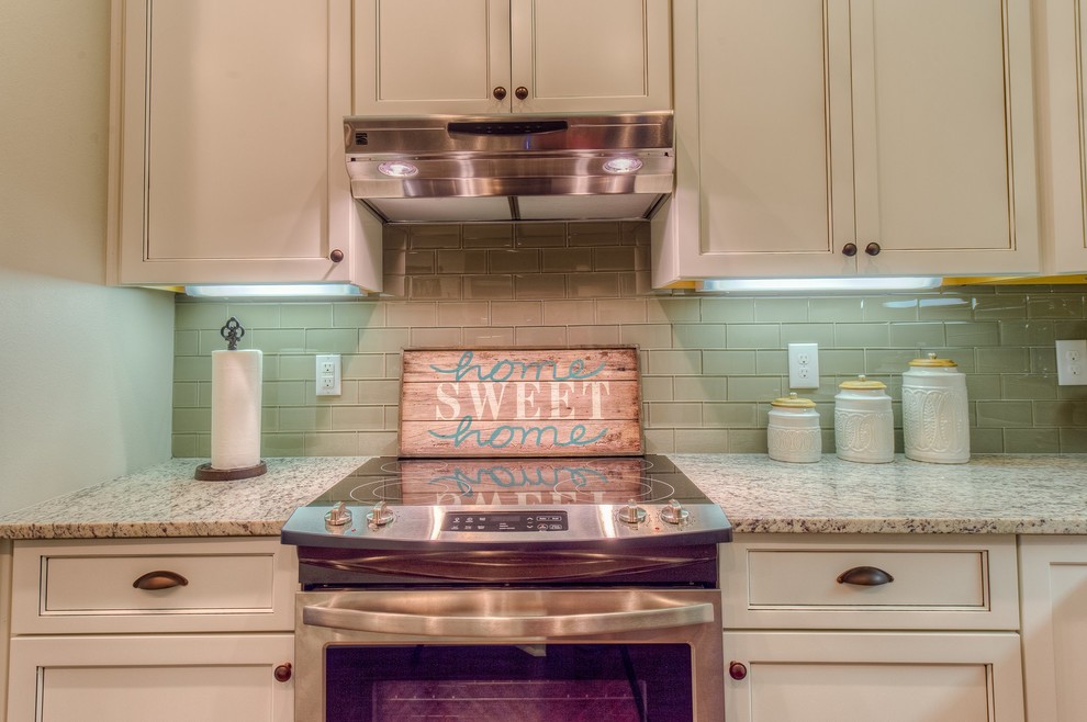 Mid-sized transitional l-shaped medium tone wood floor open concept kitchen photo in Miami with shaker cabinets, white cabinets, granite countertops, beige backsplash, stainless steel appliances and an island