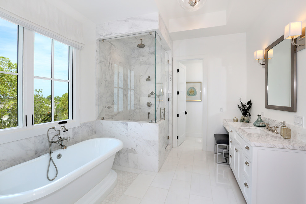 Freestanding bathtub - large master white tile ceramic tile freestanding bathtub idea in Orange County with an undermount sink, recessed-panel cabinets, white cabinets, marble countertops and white walls