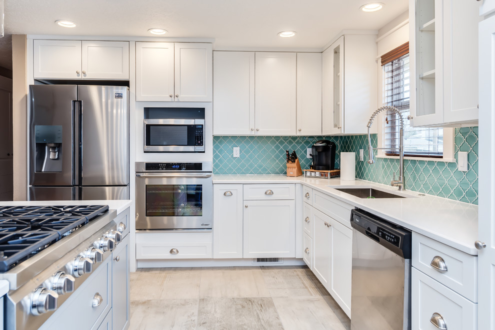Inspiration for a small transitional l-shaped porcelain tile and gray floor eat-in kitchen remodel in Boise with a single-bowl sink, shaker cabinets, white cabinets, quartz countertops, blue backsplash, glass tile backsplash, stainless steel appliances and an island