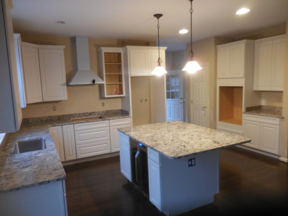 Eat-in kitchen - mid-sized transitional u-shaped dark wood floor eat-in kitchen idea in Baltimore with an undermount sink, raised-panel cabinets, white cabinets, granite countertops, gray backsplash, stone slab backsplash, stainless steel appliances and an island