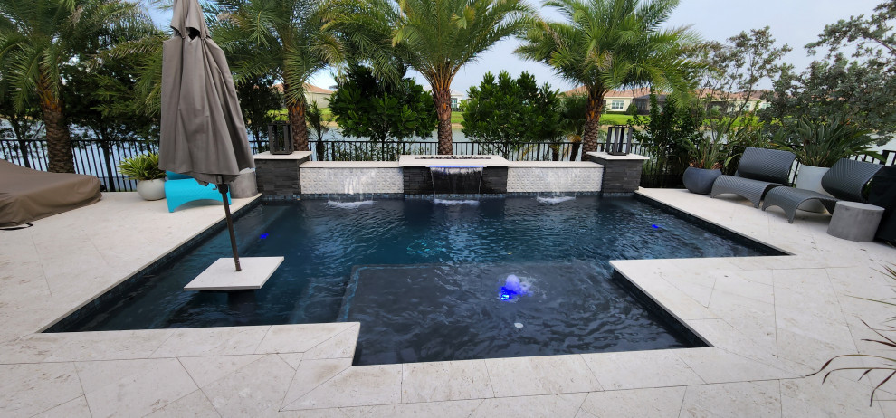 Moderner Pool hinter dem Haus mit Natursteinplatten in Miami