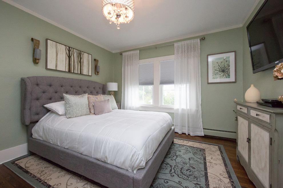 This is an example of a mid-sized arts and crafts guest bedroom in Other with green walls, dark hardwood floors and brown floor.