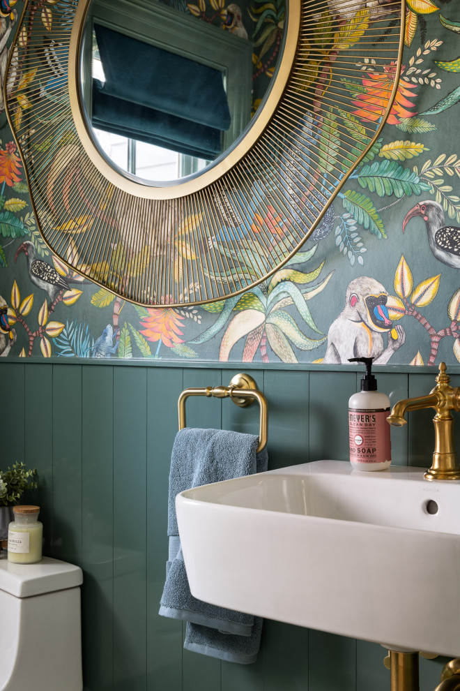Inredning av ett eklektiskt litet toalett, med en toalettstol med hel cisternkåpa, gröna väggar, mosaikgolv, ett väggmonterat handfat och grönt golv