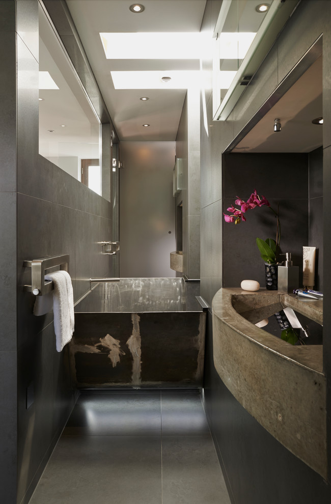 Contemporary bathroom in London with an integrated sink, a japanese tub and gray tile.