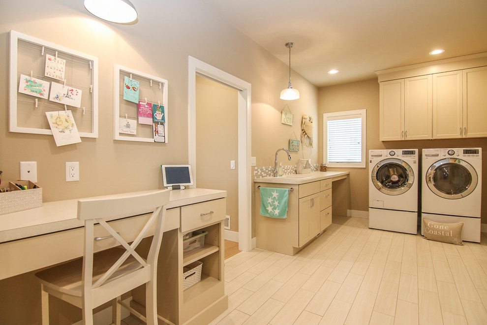 Large beach style galley utility room in Other with a drop-in sink, recessed-panel cabinets, beige cabinets, beige walls, light hardwood floors, a side-by-side washer and dryer and beige floor.
