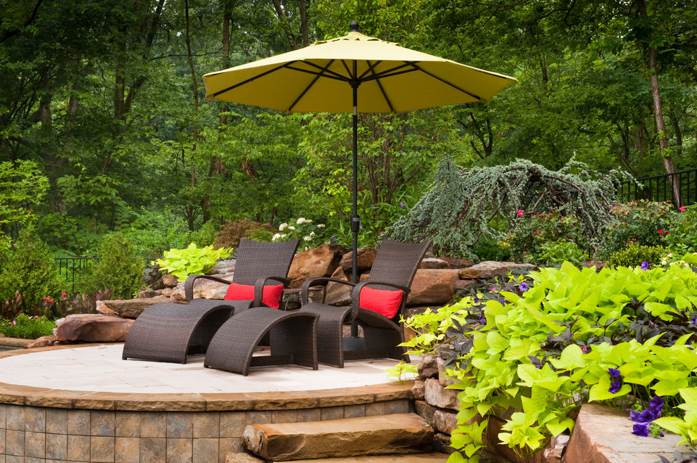 Design ideas for an expansive traditional patio in St Louis with natural stone pavers and no cover.