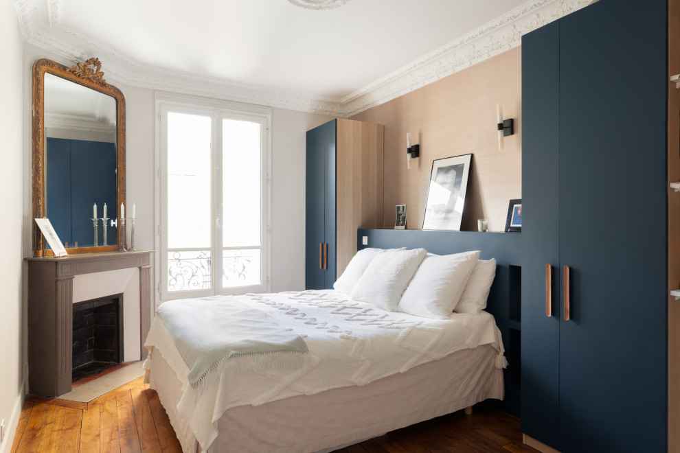 Mittelgroßes Modernes Hauptschlafzimmer mit blauer Wandfarbe, braunem Holzboden, Eckkamin, Kaminumrandung aus Backstein, Holzdecke und Tapetenwänden in Paris