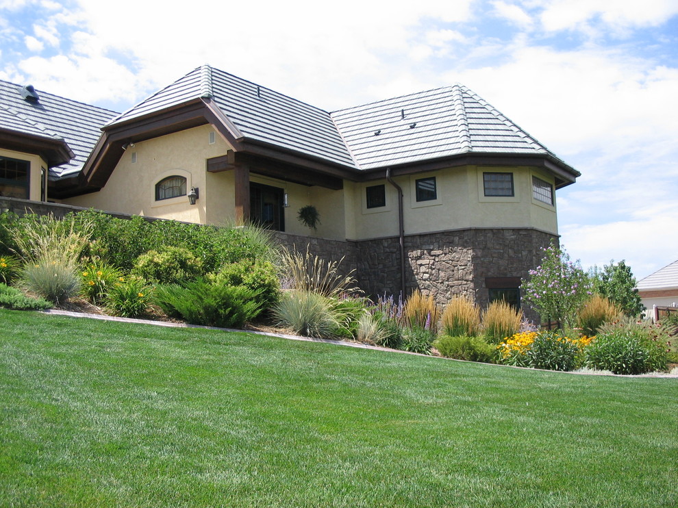Photo of a large country front yard garden in Denver with a water feature and natural stone pavers.