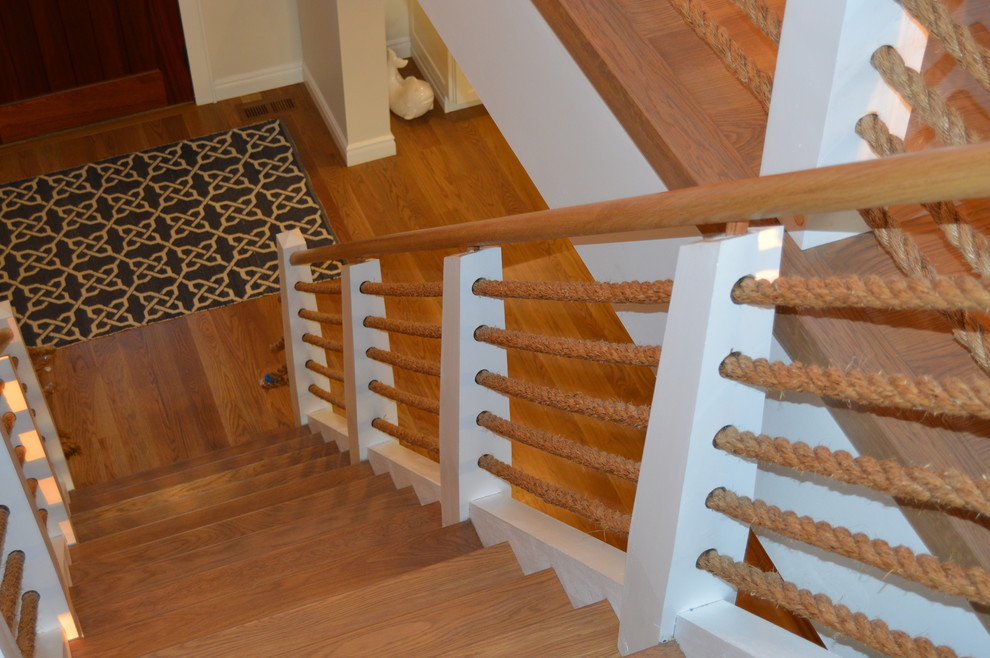 Design ideas for a beach style wood floating staircase in New York with open risers.