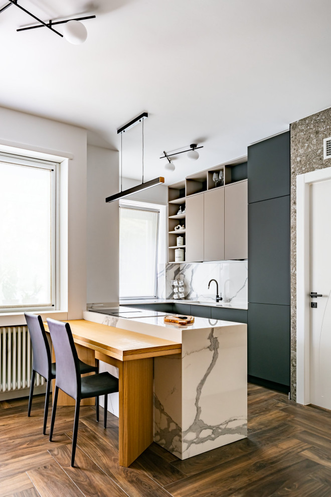 Foto på ett litet funkis vit kök, med en integrerad diskho, släta luckor, grå skåp, marmorbänkskiva, vitt stänkskydd, stänkskydd i marmor, svarta vitvaror, klinkergolv i porslin, en köksö och brunt golv