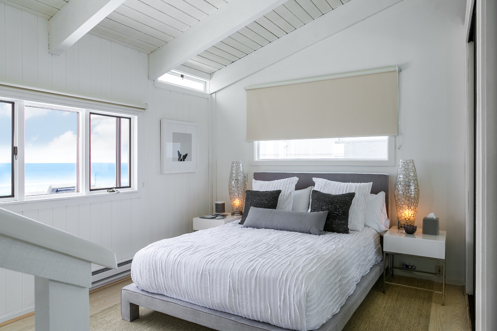 Inspiration for a small beach style guest bedroom in Los Angeles with white walls and light hardwood floors.