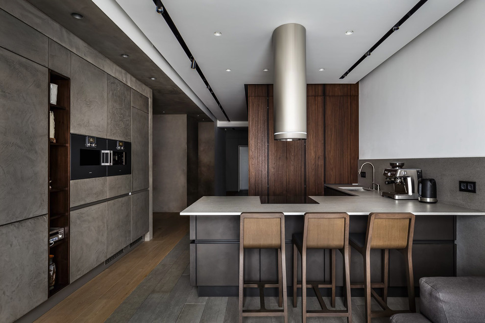 Contemporary u-shaped open plan kitchen in Moscow with an undermount sink, flat-panel cabinets, grey splashback, black appliances, a peninsula, grey floor, concrete benchtops and cement tile splashback.