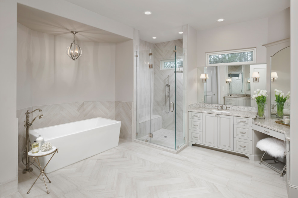 Design ideas for a traditional master bathroom in Houston with raised-panel cabinets, beige cabinets, a freestanding tub, an alcove shower, beige tile, beige walls, an undermount sink and a hinged shower door.
