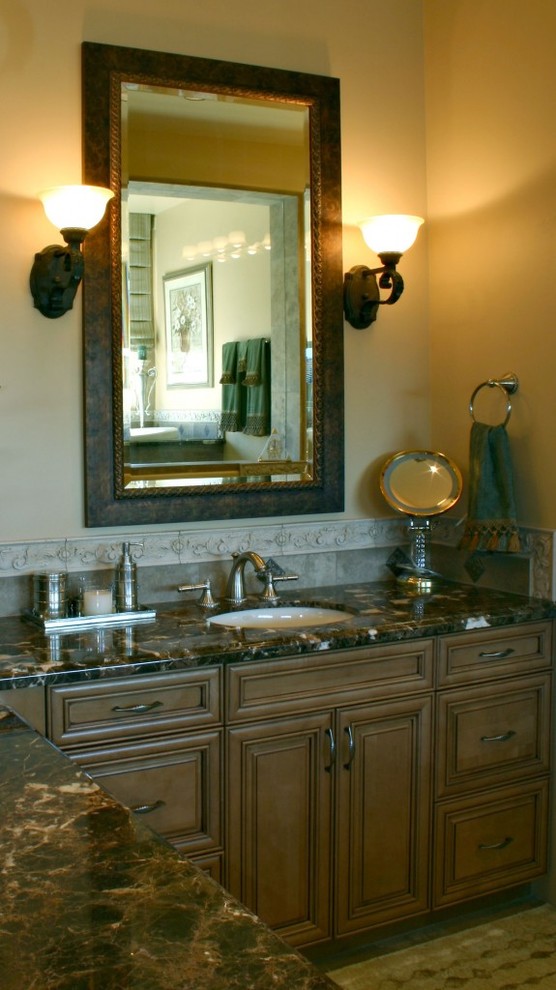 Photo of a mediterranean master bathroom in Phoenix with beaded inset cabinets, medium wood cabinets, gray tile, stone tile, beige walls, slate floors, an undermount sink and granite benchtops.