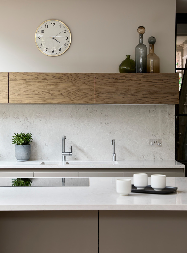 Contemporary eat-in kitchen in Other with a double-bowl sink, flat-panel cabinets, beige cabinets, quartz benchtops, white splashback, engineered quartz splashback, black appliances, light hardwood floors, with island, beige floor and white benchtop.