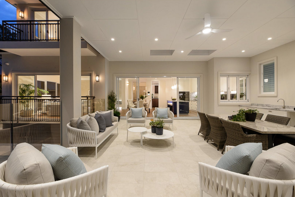 Photo of a large beach style backyard patio in Sydney with an outdoor kitchen, tile and a roof extension.