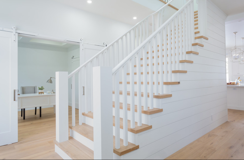 Diseño de escalera recta de estilo de casa de campo grande con escalones de madera, contrahuellas de madera pintada, barandilla de madera y machihembrado
