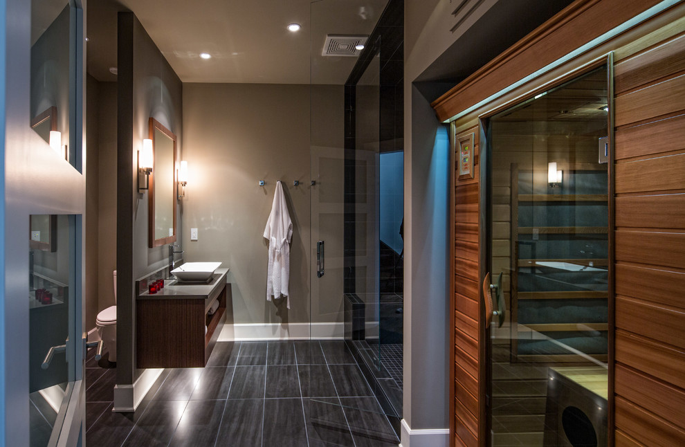 Design ideas for a mid-sized contemporary bathroom in Vancouver with open cabinets, dark wood cabinets, an alcove shower, a two-piece toilet, grey walls, porcelain floors, with a sauna, a vessel sink, engineered quartz benchtops, black floor and a hinged shower door.