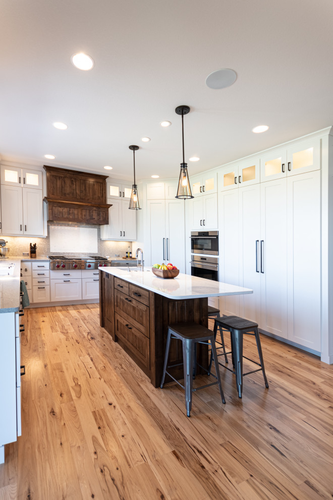 Kitchen - large transitional u-shaped light wood floor and beige floor kitchen idea with shaker cabinets, white cabinets, white backsplash, colored appliances, an island and gray countertops