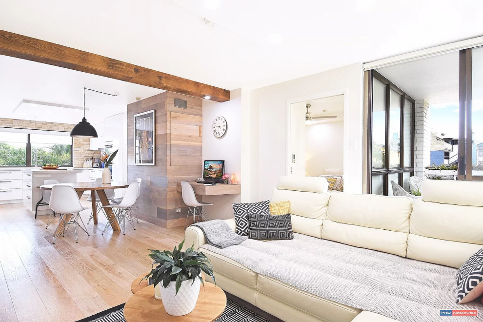 Design ideas for a mid-sized scandinavian open concept living room in Gold Coast - Tweed with white walls, medium hardwood floors, a standard fireplace, a stone fireplace surround and beige floor.