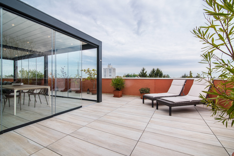 Ispirazione per una privacy sulla terrazza design di medie dimensioni, sul tetto e sul tetto con una pergola e parapetto in vetro