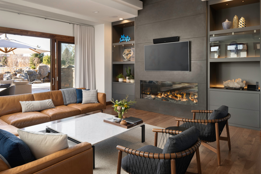 Ejemplo de sala de estar abierta contemporánea grande con paredes blancas, suelo de madera en tonos medios, chimenea lineal, marco de chimenea de hormigón, televisor colgado en la pared y suelo marrón