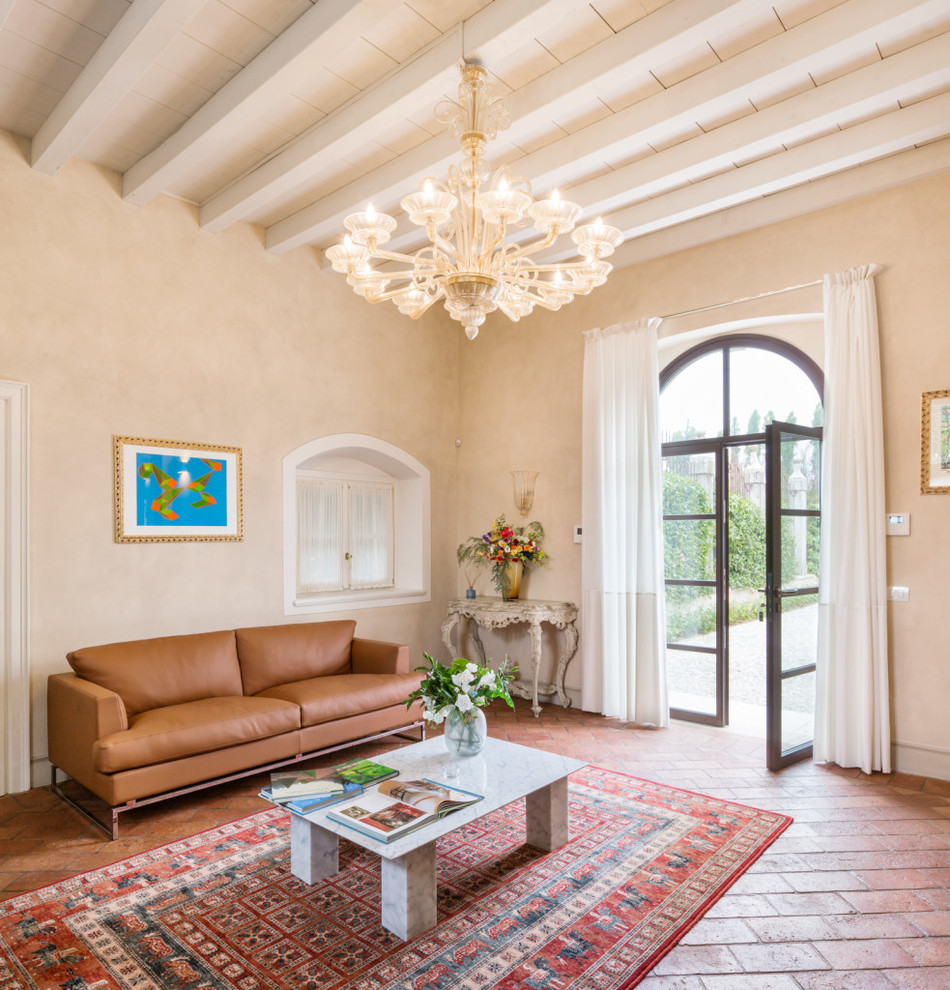 Mid-sized mediterranean enclosed living room in Milan with beige walls and brick floors.