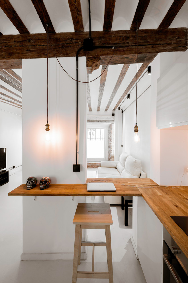 Medium sized industrial l-shaped open plan kitchen in Madrid with a submerged sink, brown splashback, wood splashback, white appliances, an island, white floors, brown worktops and exposed beams.