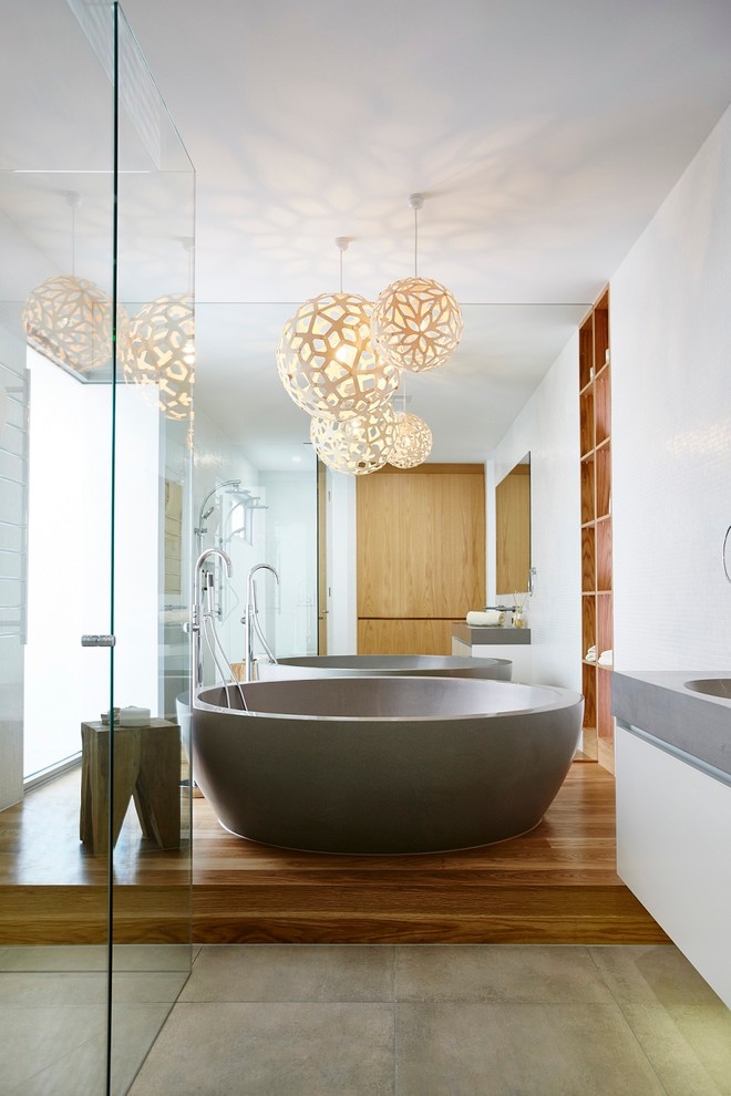 Inspiration for a contemporary master bathroom in Melbourne with flat-panel cabinets, a freestanding tub, a shower/bathtub combo, white walls, an integrated sink, concrete benchtops and white cabinets.