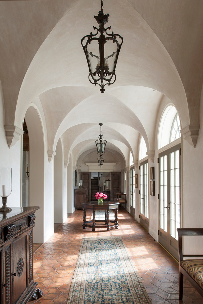 Design ideas for a traditional hallway in Houston with beige walls and terra-cotta floors.