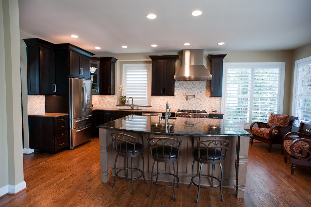 Inspiration for a mid-sized transitional l-shaped kitchen remodel in Charlotte with dark wood cabinets, granite countertops, white backsplash and an island