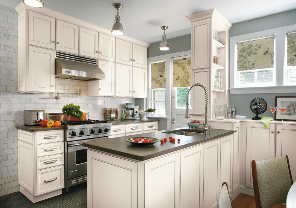Inspiration for a large traditional galley eat-in kitchen in Indianapolis with an undermount sink, recessed-panel cabinets, white cabinets, concrete benchtops, grey splashback, subway tile splashback, stainless steel appliances, light hardwood floors and a peninsula.