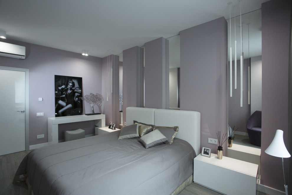 This is an example of a contemporary master bedroom in Other with pink walls, medium hardwood floors and grey floor.