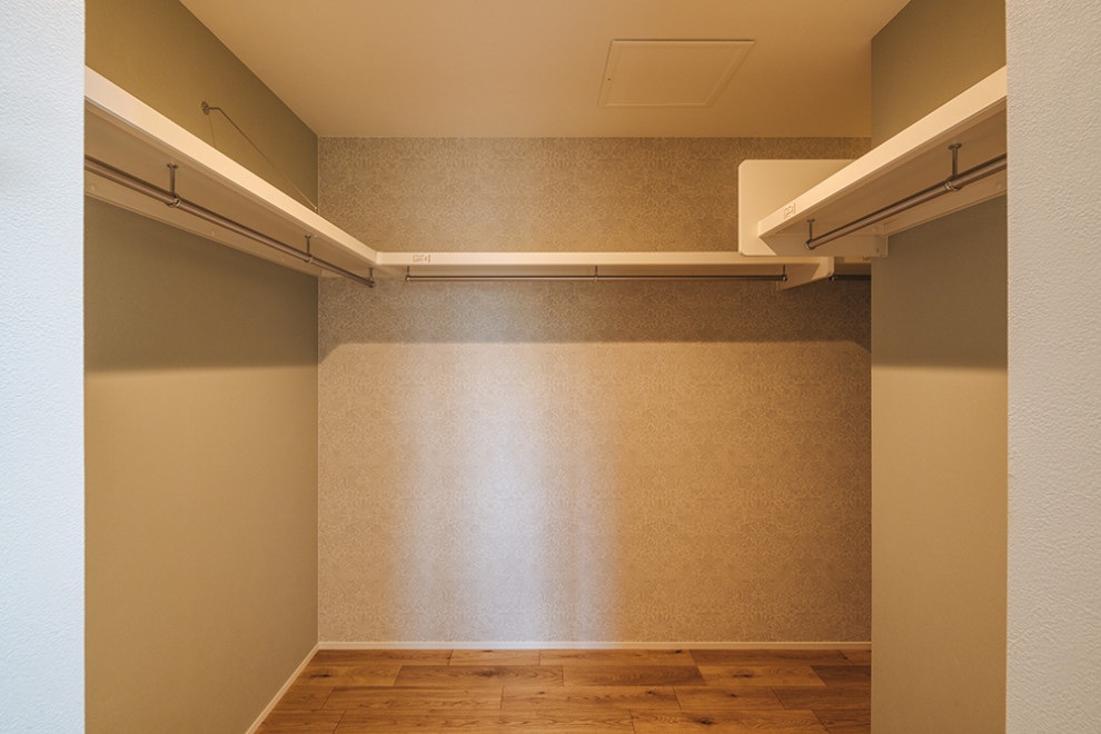 Foto på en mellanstor garderob, med mellanmörkt trägolv och beiget golv