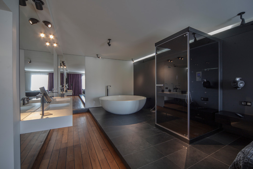 Photo of a large contemporary master bedroom in Other with multi-coloured walls, slate floors and black floor.
