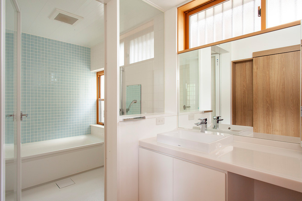 Mid-sized modern bathroom in Tokyo with beaded inset cabinets, white cabinets, white tile, white walls, vinyl floors, solid surface benchtops, beige floor, white benchtops, a freestanding vanity and wallpaper.