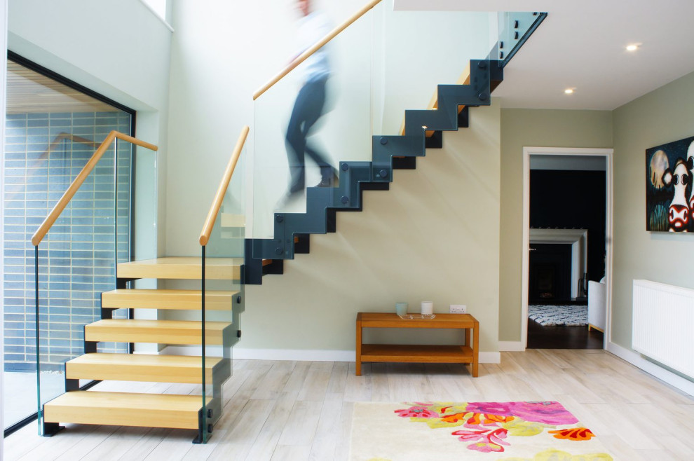 Design ideas for a modern wood straight staircase in Other with open risers and glass railing.
