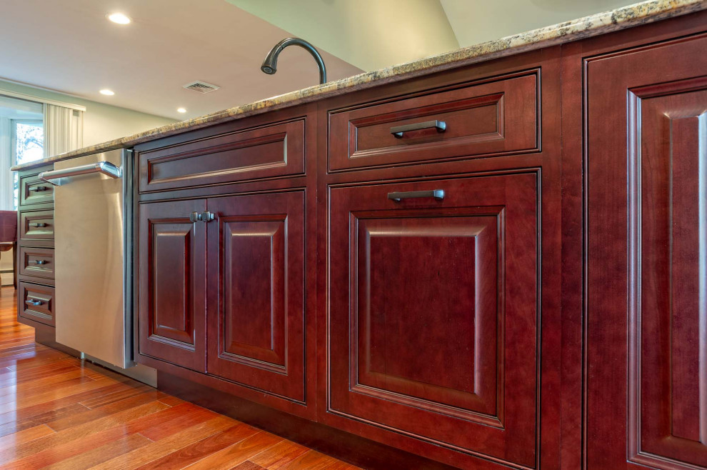 Large transitional single-wall light wood floor and brown floor eat-in kitchen photo in Philadelphia with an undermount sink, raised-panel cabinets, red cabinets, granite countertops, brown backsplash, porcelain backsplash, stainless steel appliances, an island and brown countertops