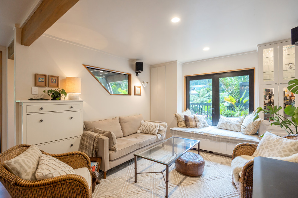 Kleines, Offenes Eklektisches Wohnzimmer mit weißer Wandfarbe, Korkboden, Kaminofen und braunem Boden in Auckland
