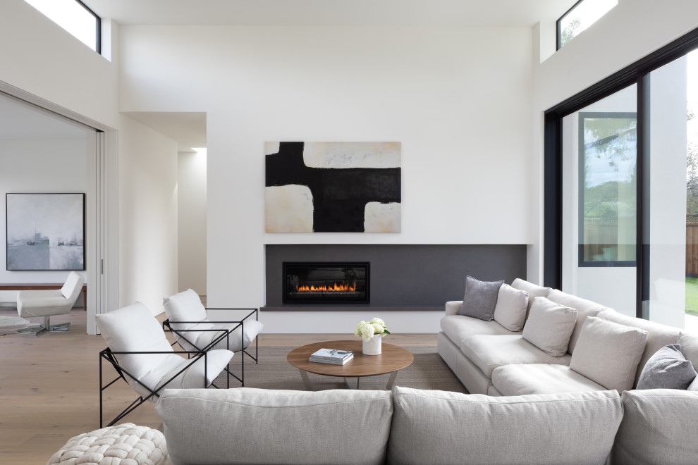 Photo of a modern living room in San Francisco with a standard fireplace and a stone fireplace surround.