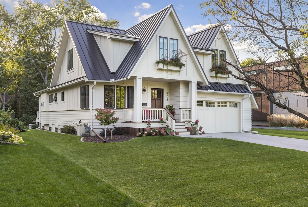 This is an example of a mid-sized country two-storey white house exterior in Minneapolis with concrete fiberboard siding, a gable roof and a metal roof.