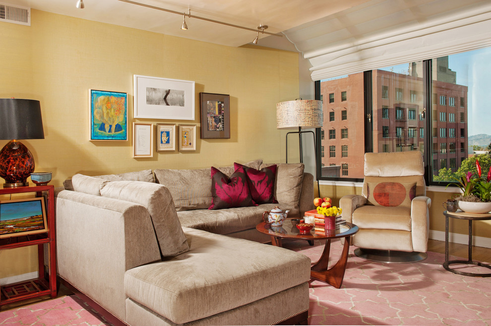 This is an example of a mid-sized transitional open concept living room in San Francisco with yellow walls, medium hardwood floors, a freestanding tv and grey floor.