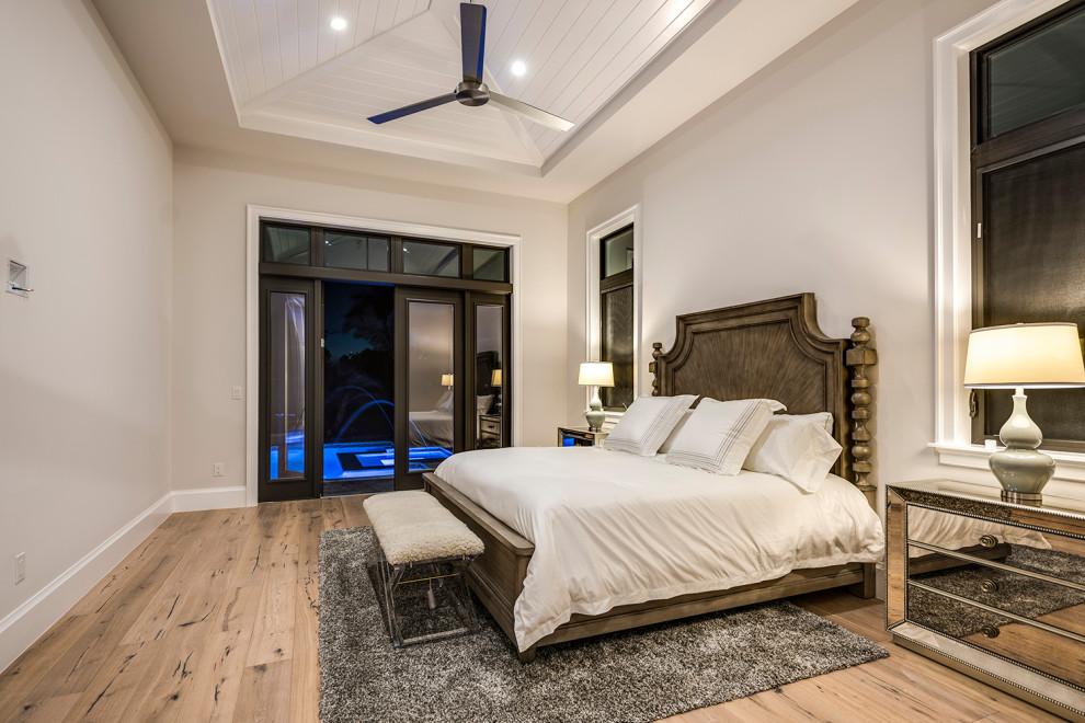 Modelo de dormitorio principal y abovedado marinero de tamaño medio con paredes grises y suelo de madera en tonos medios